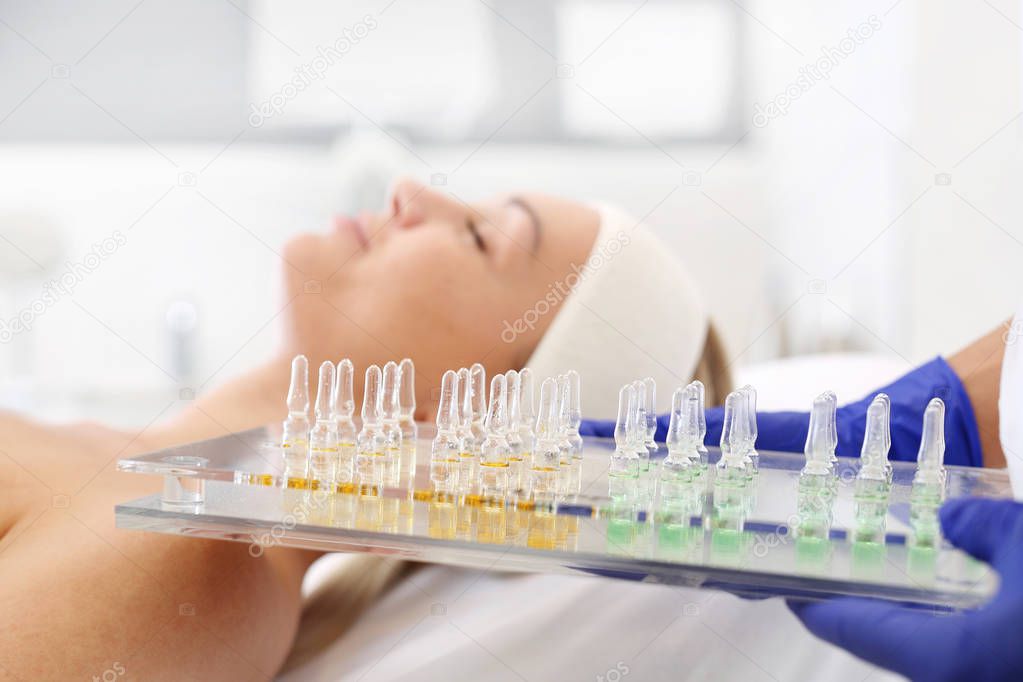 Cosmetics in an ampoule.The beautician holds trays with cosmetic preparations in her hand. 