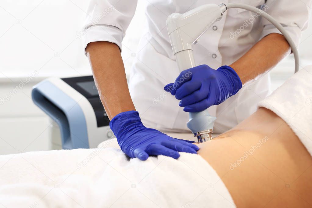 A flat stomach, a firming treatment.The beautician performs the treatment using the machine.