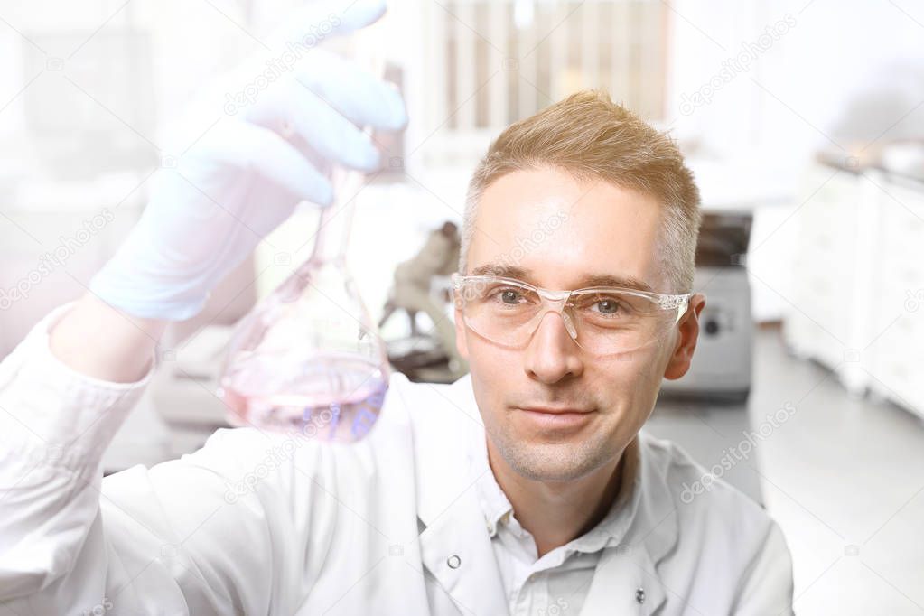 Chemist. A scientist is holding a test tube with a solution.