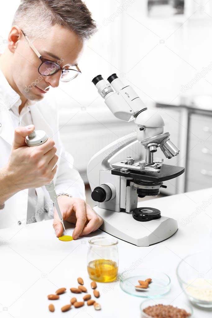Examination under a microscope. The lab technician analyzes the microscope in the laboratory lab.