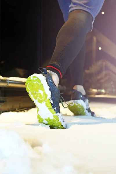 Running in the winter. Running in the winter at night, runner\'s shoes in the snow.