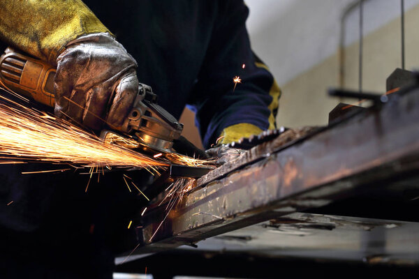 Metalworking. The man polishes the steel grinder.