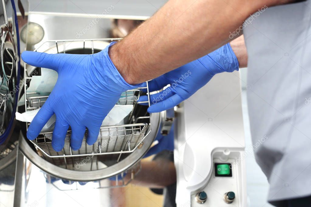 Sterilization of medical instruments. The doctor removes sterile packages prepared for the procedure.