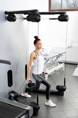 Eğitim, eğitim makinede bir yük ile genç bir kadın alıştırmaların spor salonu.