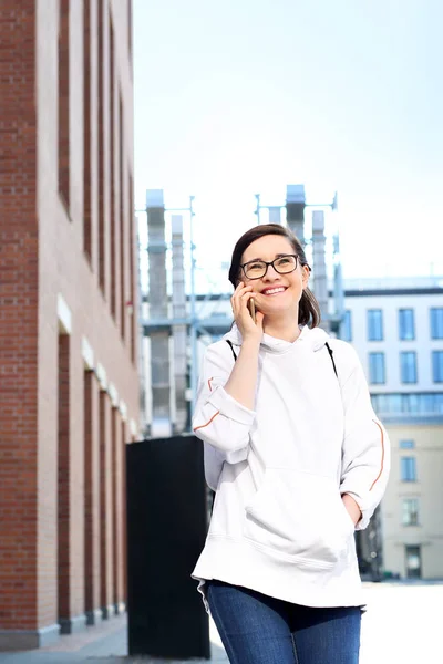 Conversa telefónica. Sorrindo natural jovem mulher falando ao telefone . — Fotografia de Stock