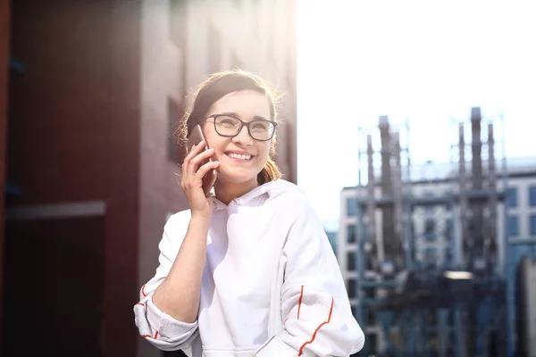 Szczęśliwa, uśmiechnięta młoda kobieta rozmawiająca przez telefon. — Zdjęcie stockowe