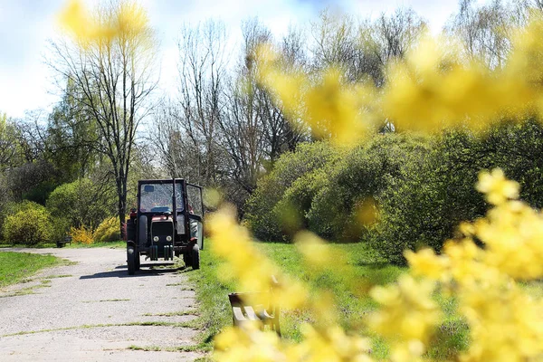 Tractor agrícola. Un vehículo agrícola en un camino de parque . —  Fotos de Stock