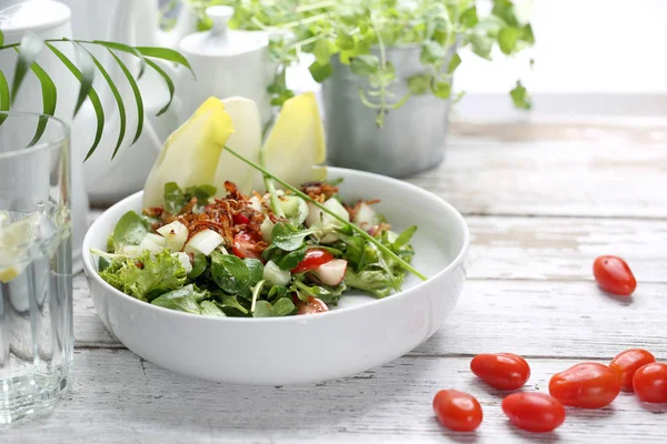 Salad with chicory, rapunzel, tomatoes, radish. A green, healthy vegetarian diet. — Stock Photo, Image