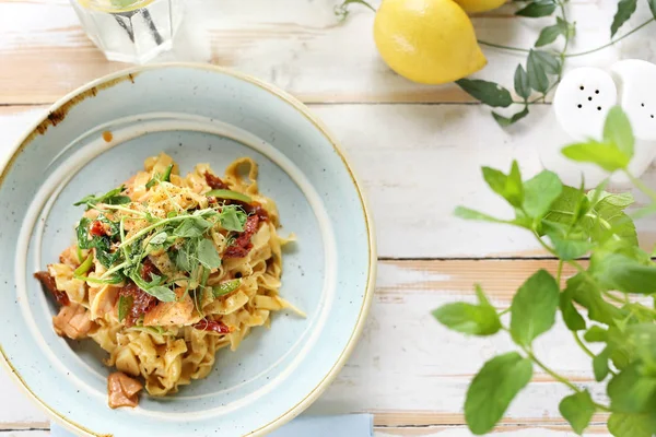 Tagliatelle with salmon and sun-dried tomatoes. Appetizing dish. Top view — Stock Photo, Image