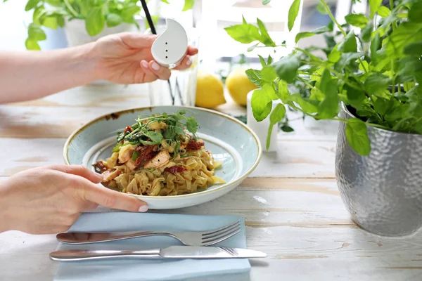 サーモンと日干しトマトのスパゲッティ。女性はおいしい料理を食べる — ストック写真