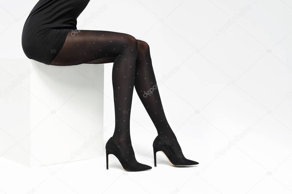 Tights. Black covering tights. Female legs in shoes on a stiletto dressed in tights