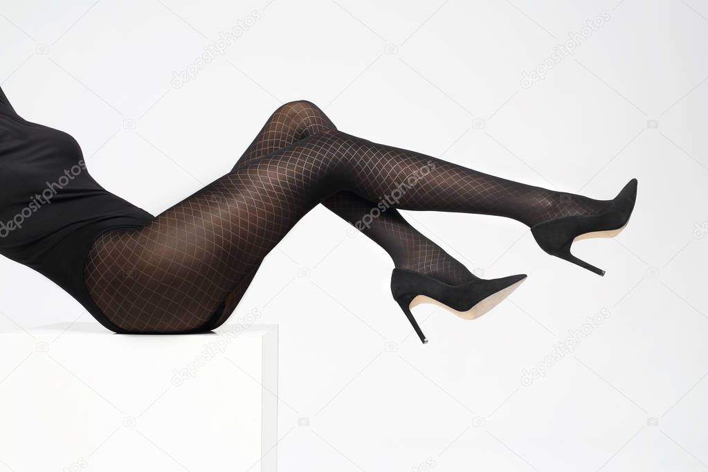 Tights. Black covering tights. Female legs in shoes on a stiletto dressed in tights