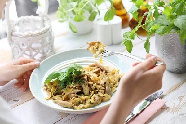 Pasta with oyster mushrooms. The woman eats a tasty dish. — Stock Photo, Image