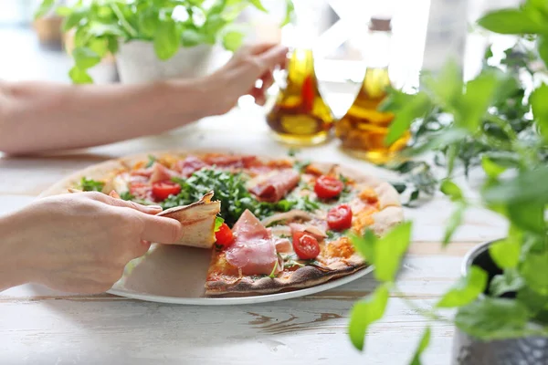 Pizza, pizza tradicional italiana sobre una fina masa crujiente con jamón de Parma, tomates y ensalada de rúcula verde . — Foto de Stock