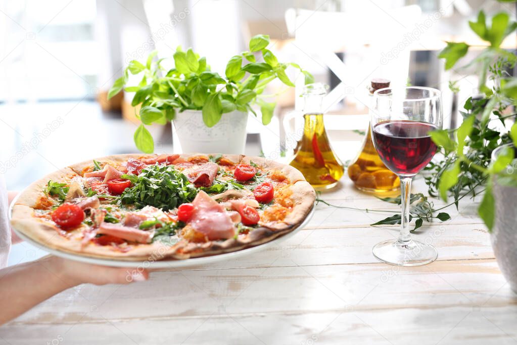 Pizza, traditional Italian pizza on a thin crunchy dough with Parma ham, tomatoes and green rocket salad.