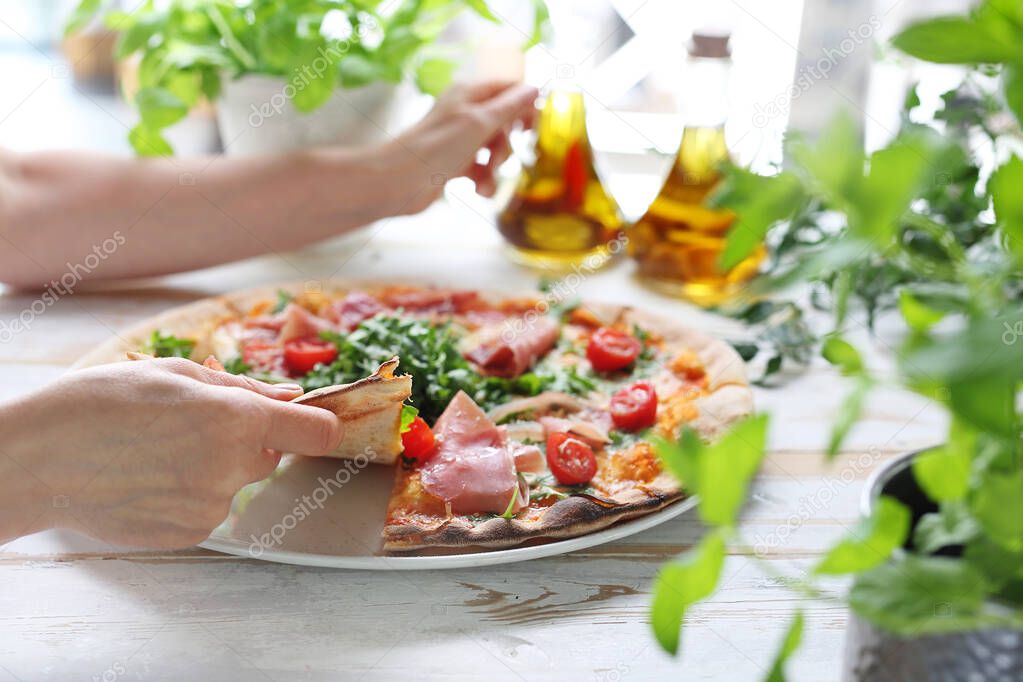 Pizza, traditional Italian pizza on a thin crunchy dough with Parma ham, tomatoes and green rocket salad.
