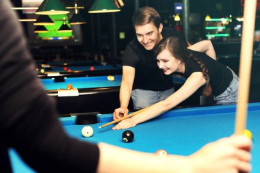 Bilardo oyunu. Bir kadın ve bir adam kulüpte bilardo oynuyorlar.