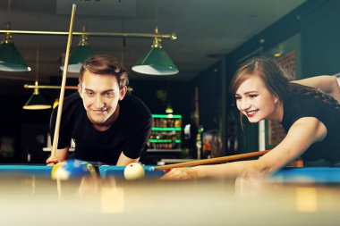 Bilardo oyunu. Bir kadın ve bir adam kulüpte bilardo oynuyorlar.