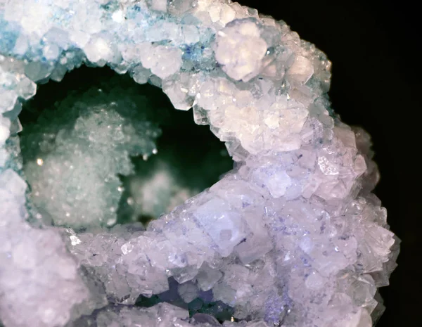 Gemstone closeup as a part of a cluster filled with rock crystals.