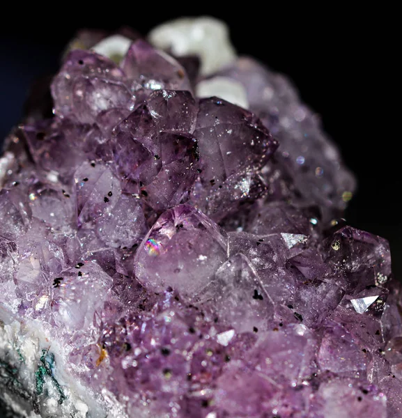 Gemstone Amethyst closeup as a part of cluster geode filled with rock Quartz crystals.