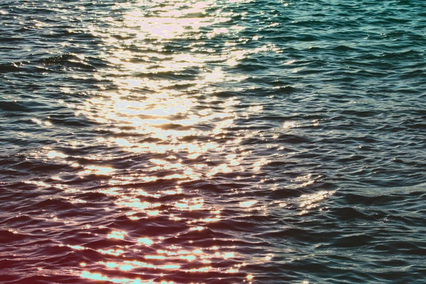 Tranquil and shiny water texture in a summer river, sea, ocean or swimming pool.