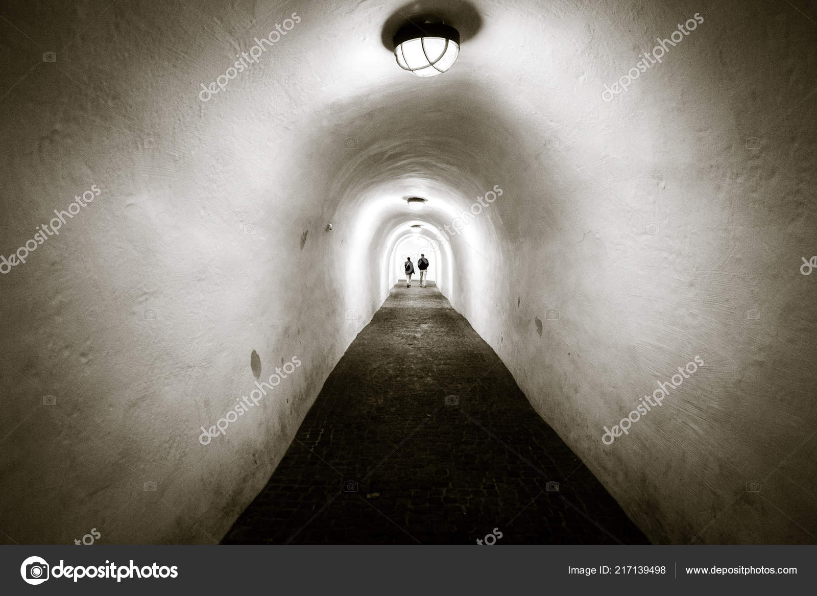Long Tunnel White Walls Arched Ceiling Two People Walking End