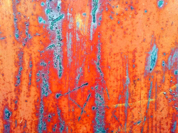 Old bright orange painted metal surface with rusty stains and scratches
