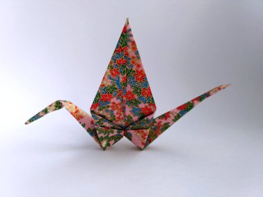 Geleneksel kağıt ile sonbahar yaprakları süsleme pembe üzerinde yapılan origami turna