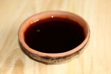 Ahşap masa üzerinde bir kil Kupası'nda kırmızı şarap