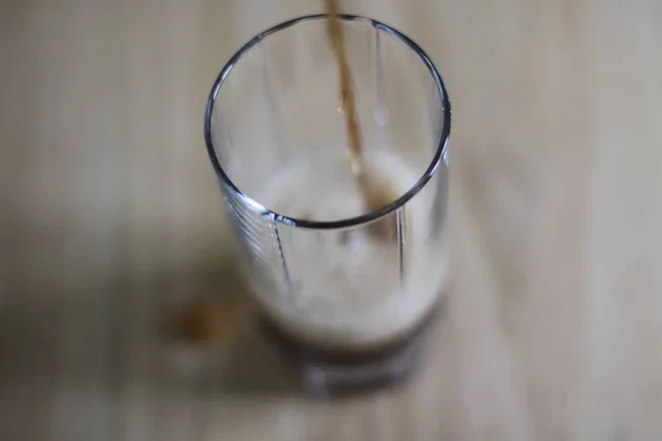 Sweet carbonated drink is pouring into glass cup