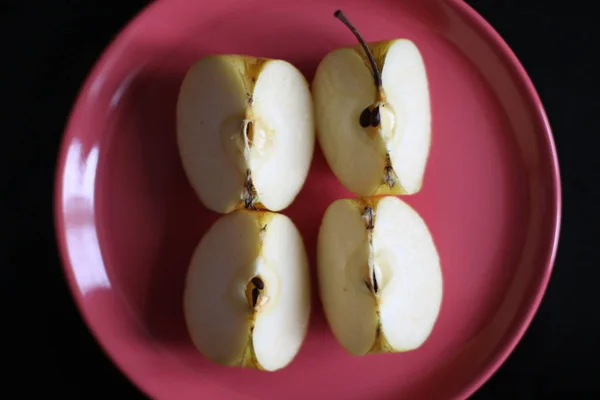 Four pieces of apple on red plate