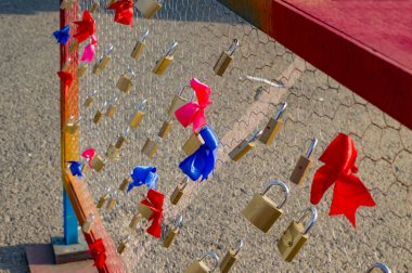 Kırmızı ve mavi kurdeleler çit üzerinde kilitleri ile