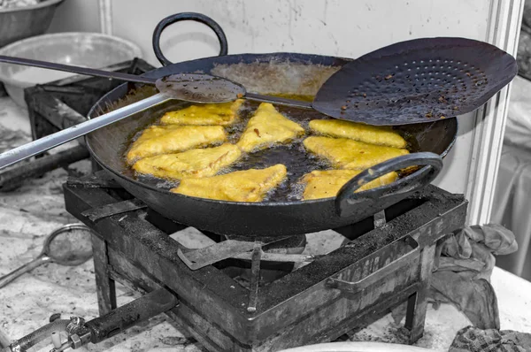 Frying bread pakode in pan with oil