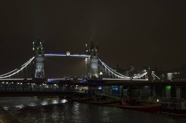 Gece ışıkları ve thames Nehri'nin su yansıma tarafından aydınlatılmış Londra kule Köprüsü