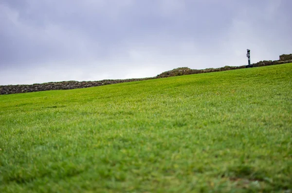A inclinação verde da grama e também as nuvens no céu — Fotografia de Stock