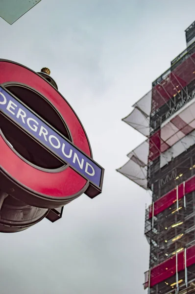 The round red sign of underground before big ben in london — Stock Photo, Image