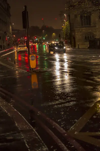 A reflecion a forgalom és a fények a nedves utcáin Londonban éjszaka éjjel a víz eső — Stock Fotó