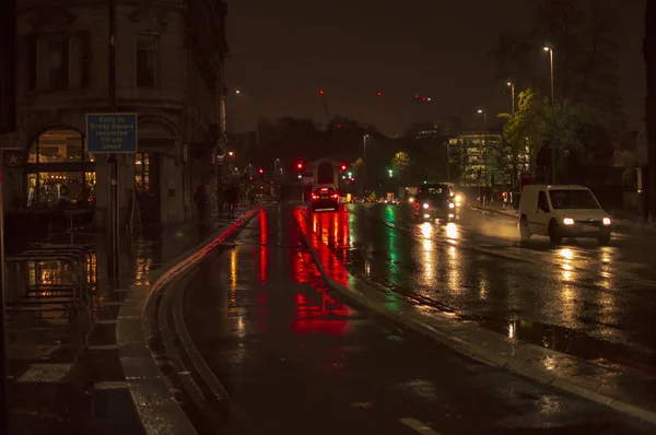 Odraz provozu a světel v mokrých ulicích Londýna v noci a osvětlený — Stock fotografie
