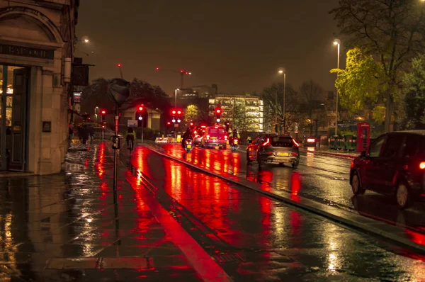 The reflecion of traffic and lights in the wet streets of london during night with bright and illuminated road — Stock Photo, Image
