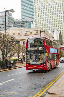 Kanarya rıhtım koyu binaları ve kırmızı otobüs ile thames nehri ile geçen