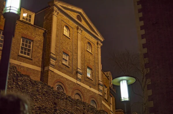 De ramen op bakstenen muur in Londen 's nachts met verlichting — Stockfoto