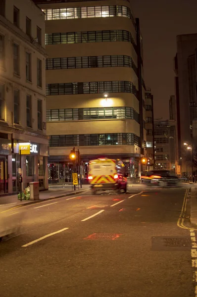 London street and buildings at night with windows and vehicles — Stock Photo, Image