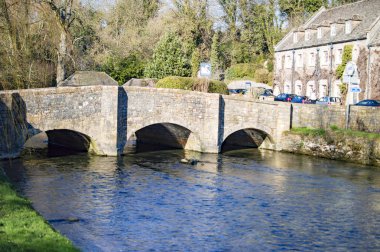 Cotswolds Bibury köyünde berrak su üzerinde taş köprü