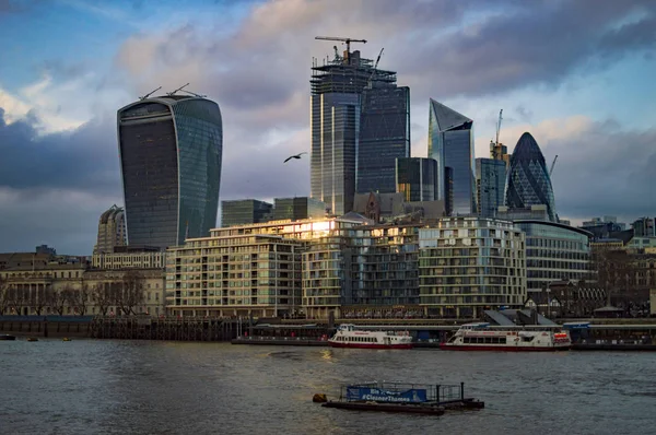 Edificios del sureste de Londres con nubes en el cielo y barcos navegando en el río —  Fotos de Stock