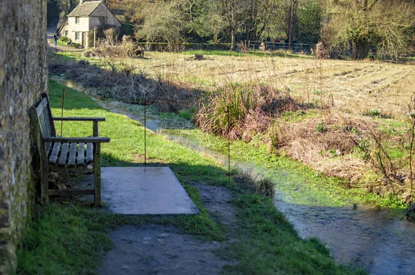 Bibury village in cotswolds and old houses with a chair outside — Stock Photo, Image