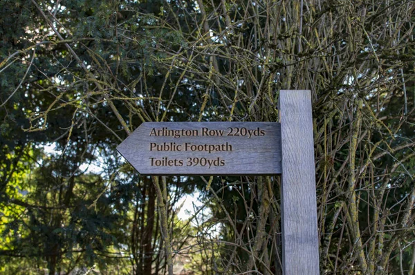 Bibury pueblo en cotswold y un letrero que muestra la dirección de los baños —  Fotos de Stock