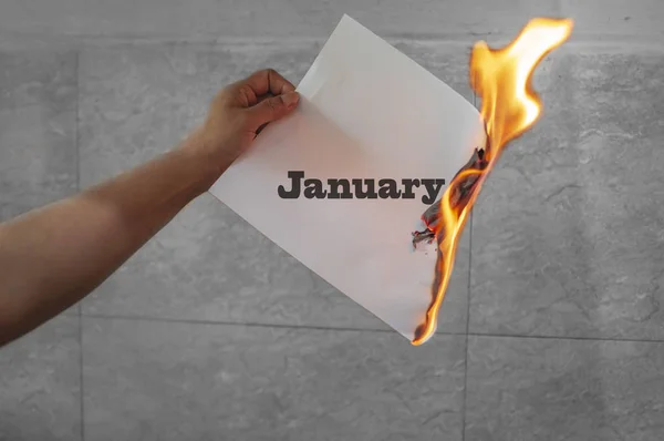 Lednové slovo text na ohni s hořícím papírem — Stock fotografie