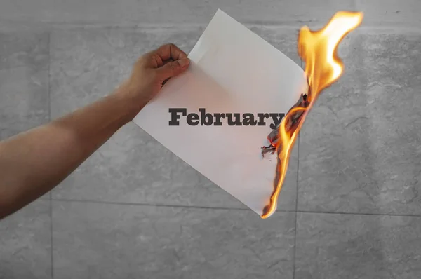 Palabra de febrero texto en llamas con papel quemado — Foto de Stock