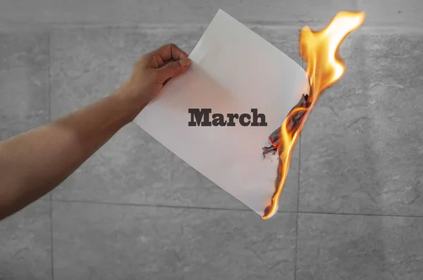 Palabra de marzo texto en llamas con papel quemado — Foto de Stock