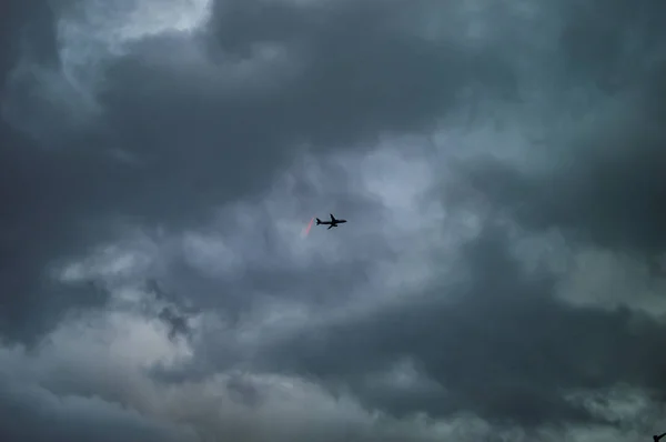 Avión Lonon en el cielo con nubes blancas y negras —  Fotos de Stock